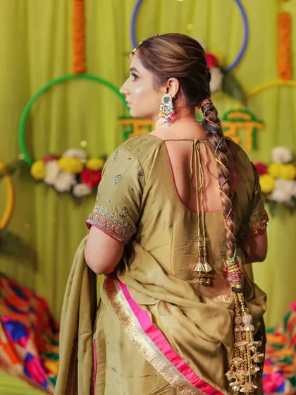 A shot from the back, highlighting the bride's beautiful hairstyle and traditional parandi.