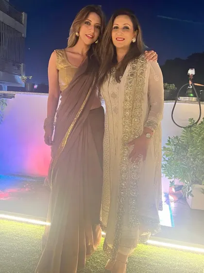 Posing with my sister. We're both in sarees, showing our different personal styles.