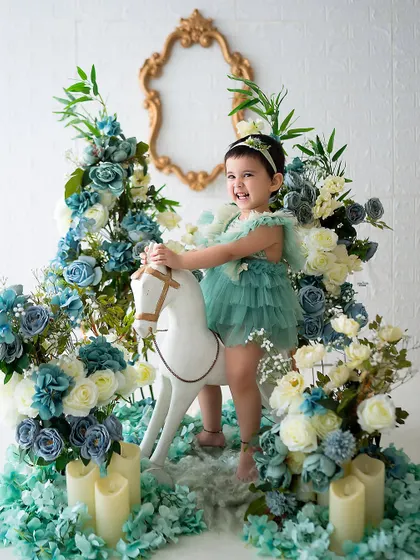 A joyful ride on the rocking horse through a garden of blue and white flowers.