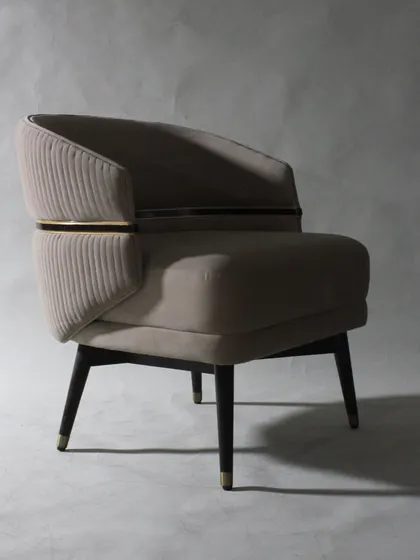 The dramatic lighting in this shot highlights the chair's sculptural form and luxurious materials.