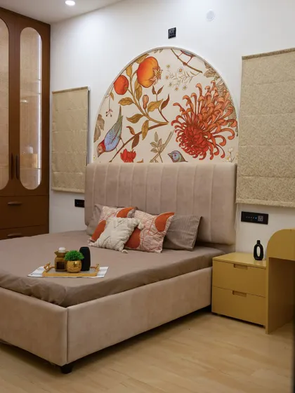 The full view of the bedroom with the arched floral mural, complemented by a neutral bed and a pop of yellow in the side table.