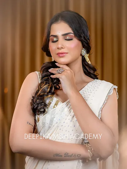 The model with her eyes closed, giving a better view of the stunning gold and brown smokey eye makeup. This is a perfect look for an evening event.
