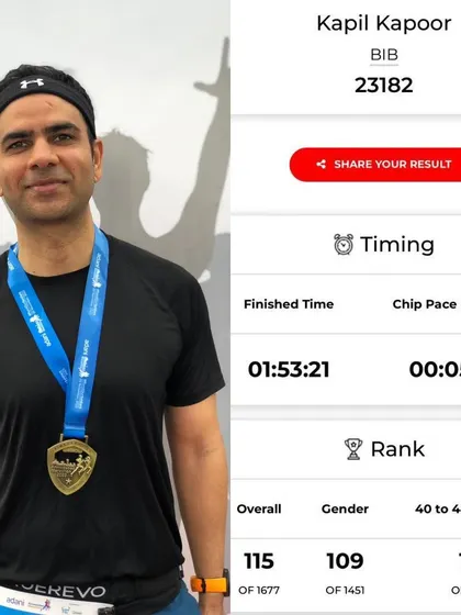 A runner with his medal and race timing. He achieved a personal best by over 2 minutes, which is a fantastic improvement.