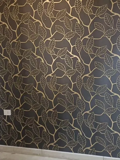 A sophisticated wallpaper with a gold leaf-and-branch outline on a dark background. This design adds a touch of luxury and elegance, perfect for a feature wall.