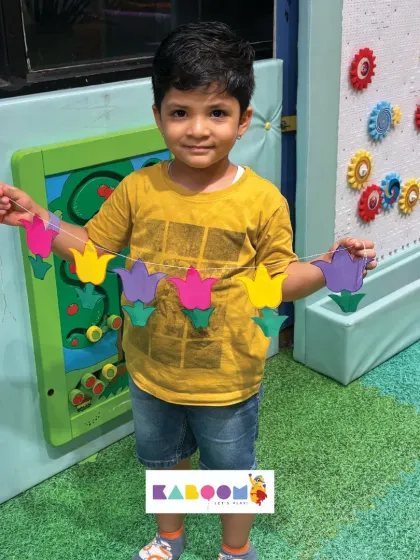 Another happy child with his completed tulip toran. These simple, guided craft activities help build confidence and fine motor skills in a fun setting.