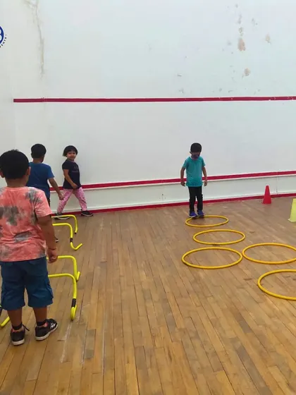 Young athletes work on their agility and coordination using hoops and hurdles. These foundational drills are crucial for developing athletic skills in any sport.