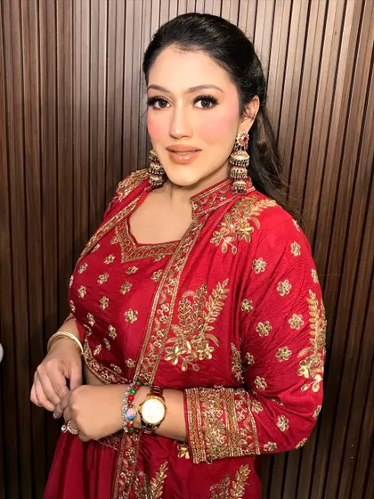A full shot of the client in her red sharara, the heavy gold jhumkas making a traditional statement.