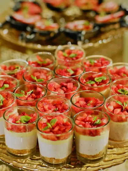 Strawberry cheesecake parfaits layered in glass cups. The vibrant red of the fresh strawberries makes this a visually appealing and refreshing dessert.