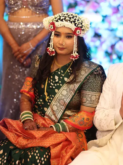 A unique look for an engagement ceremony, featuring a beautiful floral mundavalya. The makeup is kept fresh and glowing to match the celebratory mood.