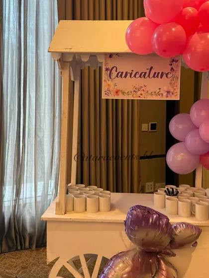 A caricature artist's station at a first birthday party. This is a wonderful and interactive party favor idea that I can arrange, giving guests a unique and personal memento to take home.