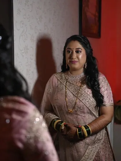 The final look in the mirror. She looks radiant and confident, ready to celebrate her big day in this beautiful peach lehenga.