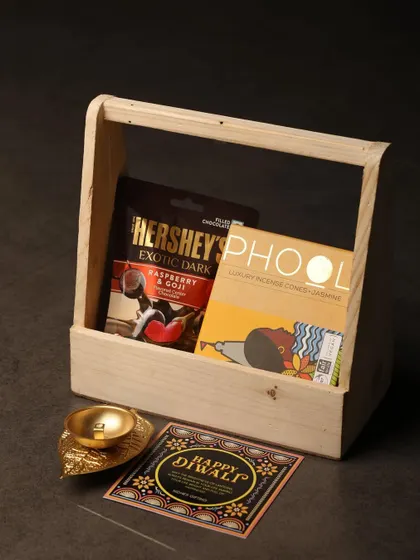This simple and elegant gift set in a wooden tray is perfect for a minimalist aesthetic. It includes a bar of Hershey's dark chocolate, Phool incense cones, and a decorative shankh diya.