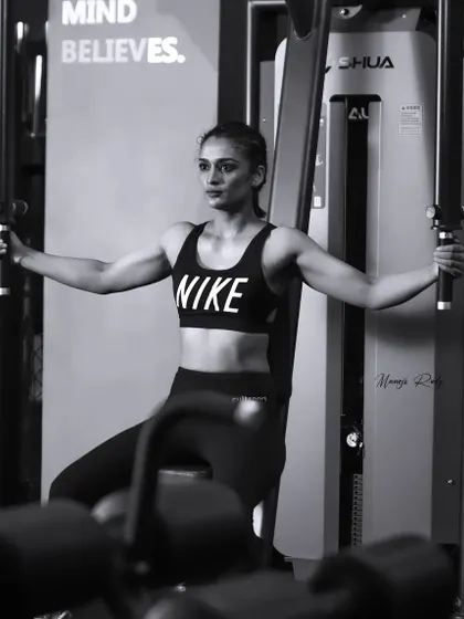 A powerful shot of a female boxer focused and ready during her workout on the pec deck machine, showcasing the strength and determination we build here.