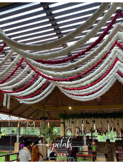 The ceiling is draped with waves of red and white floral garlands, creating a stunning visual effect.