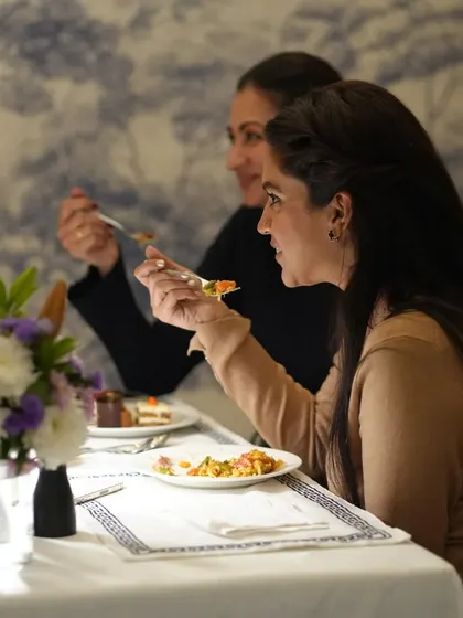 A candid moment of guests enjoying their dinner. We believe that fine dining is about more than just food; it is about the joy and connection shared at the table.