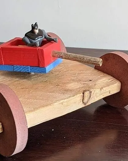 After hours of work, the wooden tanker became a vehicle for imaginative play, with Batman taking the driver's seat. This shows how children naturally blend technical skill building with creative storytelling.
