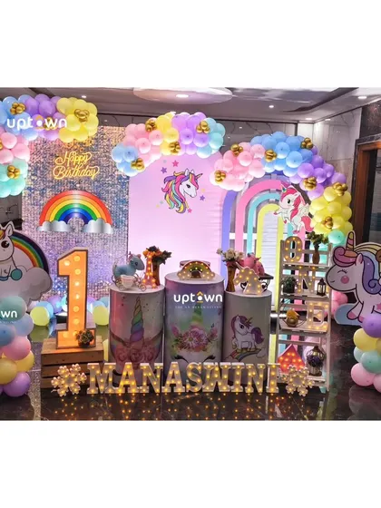 A unicorn-themed first birthday with a rainbow sequin backdrop.