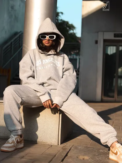 A straight-on shot that highlights the attitude of the outfit, complete with bold white sunglasses and a relaxed, powerful stance.