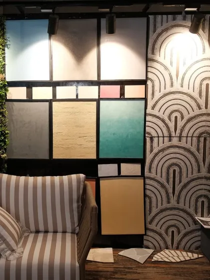 Another corner of our Casa Di Carnival booth, showcasing a striped armchair against a wall of colorful texture samples and an art-deco patterned wall.