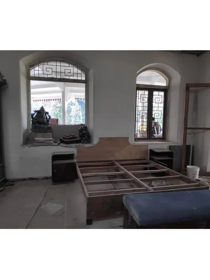 The bedroom during the restoration phase. Here you can see the bare structure, the antique wardrobe we preserved, and the new bed frame being assembled from salvaged wood.
