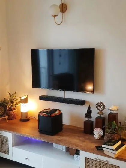 Say hello to your new favorite entertainment hub! This space is made for maximum comfort with a floating TV, warm wood console, and a pop of nature.