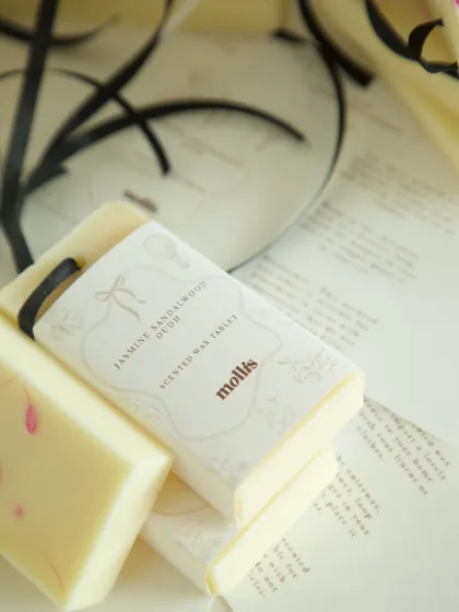 A close-up of the Jasmine Sandalwood Oudh scented wax tablet, part of a custom baby shower gift set.