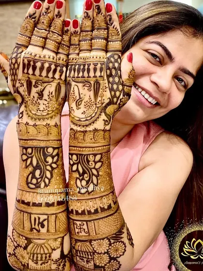 A happy client showing off her elegant backhand mehandi. The design is both traditional and stylish.