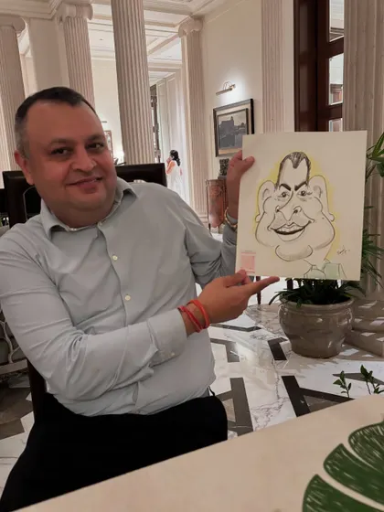 A gentleman looking quite pleased with his caricature during a relaxed evening get-together.