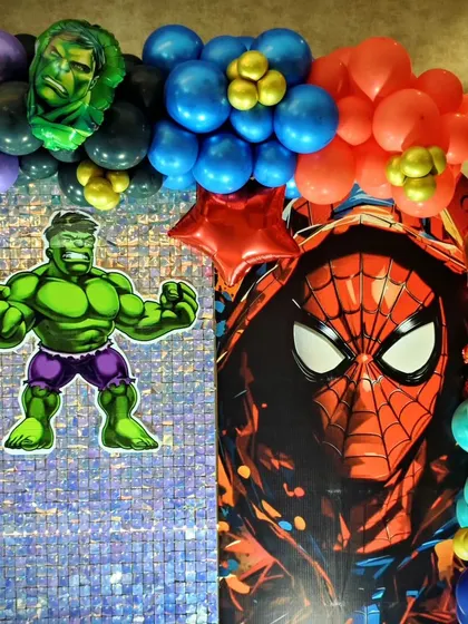A detail shot from the superhero party, showing a Hulk cutout and a Spiderman backdrop against a sequin wall.