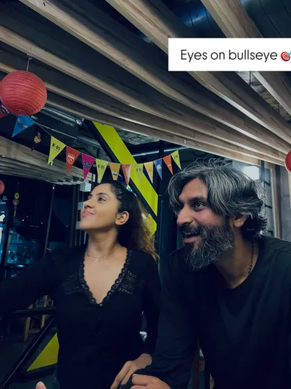 Eyes on the bullseye. A moment of focus and fun between two friends as they take aim at the dartboard.