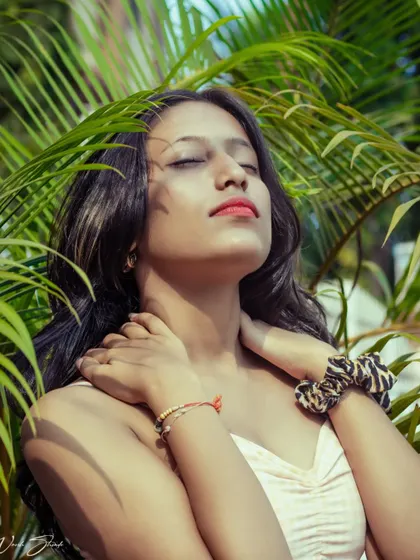 This pose, with eyes closed and face tilted towards the sun, evokes a feeling of warmth and serenity. It's a beautiful shot for a lifestyle or beauty portfolio.
