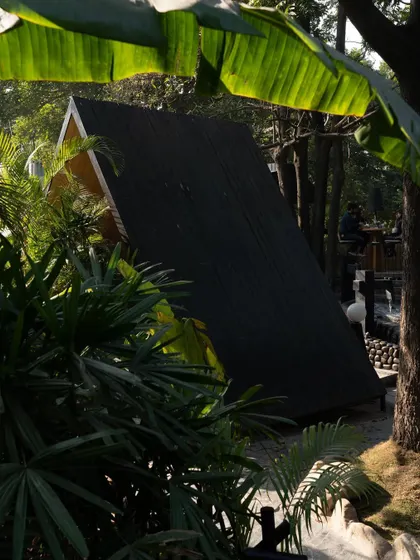 A glimpse of a Tubu pod through the dense foliage. The design blurs the line between inside and outside, creating a dining experience that is fully immersed in nature.
