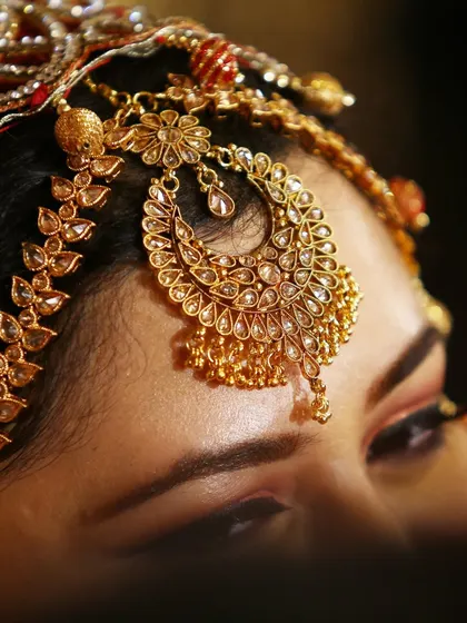 A macro shot of an ornate Maang Tikka, a key piece of bridal jewelry.
