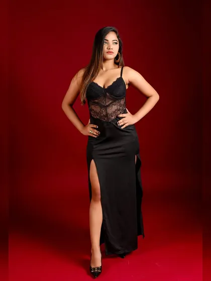 A strong, confident pose against the red studio backdrop.
