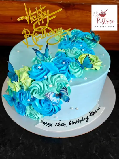 A cascade of blue and green buttercream roses and butterflies on this lovely 12th birthday cake.