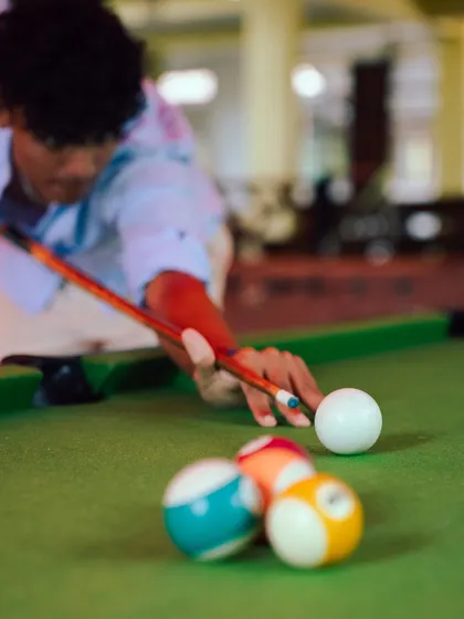 A guest focuses on their next shot in a game of pool. Our indoor game area is a popular spot to relax and socialize in the evenings.