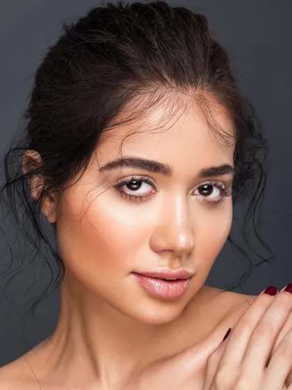 A beautiful, clean portrait with soft, flyaway hairs framing the face. The lighting is flattering, and the makeup is minimal, resulting in a look that is both polished and effortlessly natural.