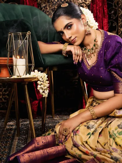 A divine look from a collaboration photoshoot. The model is wearing a beautiful antique-finish set that complements the purple and yellow floral saree perfectly.