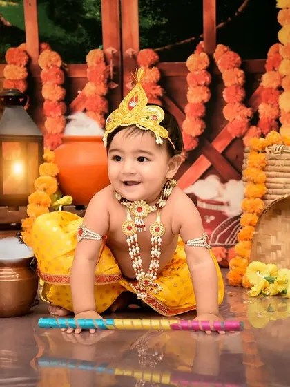 A playful little Krishna exploring the festive setup. I love capturing their curiosity as they interact with the props.