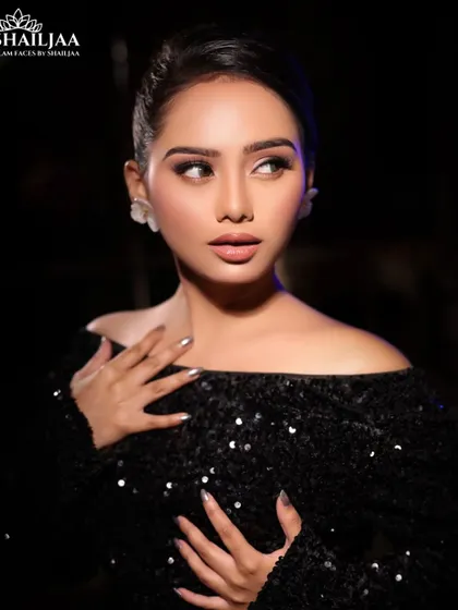 A classic cocktail look with an off-shoulder sequined black dress. The makeup is glamorous with a focus on flawless skin and defined eyes.
