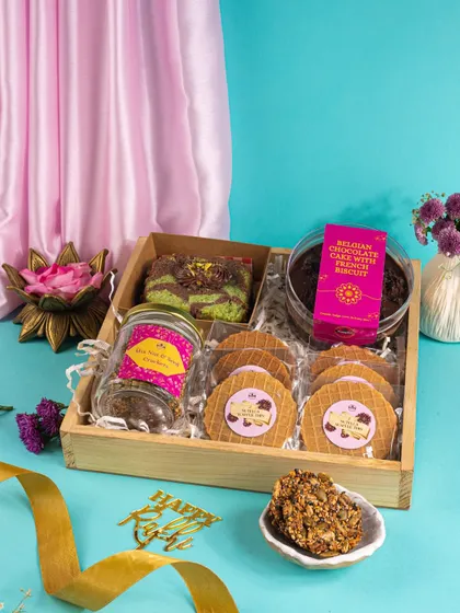 A bright and colorful Rakhi hamper with cakes and waffles, styled with a vibrant blue and pink theme to feel fresh and celebratory.