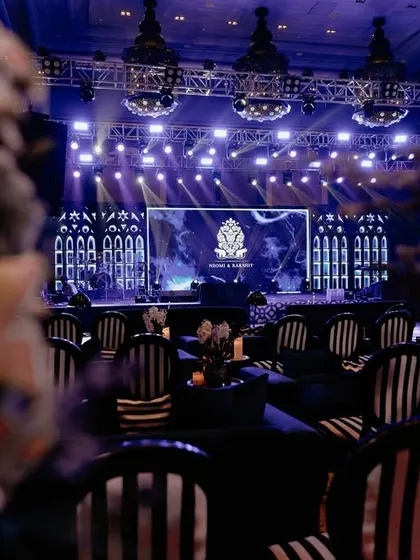A view of the Sangeet stage from the audience. The striped chairs and dramatic stage lighting created a cohesive and visually stunning experience for all the guests.
