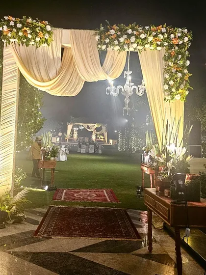 Another perspective of the dreamy outdoor entrance, with fairy lights twinkling in the trees behind. The soft smoke effect adds a touch of magic to the romantic and elegant setting.