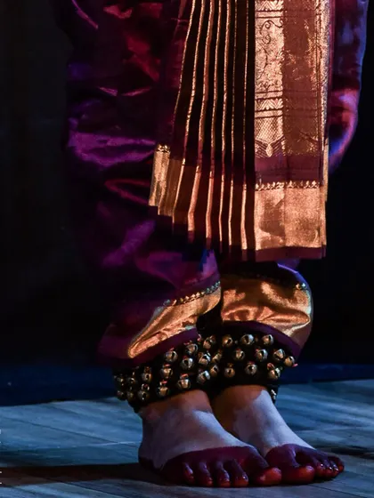 A close up of the dancer's feet adorned with ghungroo (ankle bells), essential for the rhythmic footwork of classical dance.