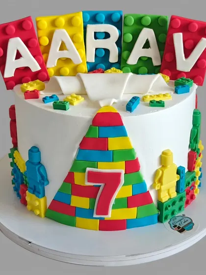 A colorful Lego-themed cake for a 7th birthday. The cake is decorated with edible Lego blocks and minifigures, making it a builder's dream.