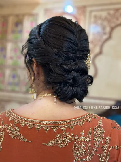 I designed this low-knotted bun with a central braid for a touch of modern elegance. The hairstyle is secured neatly at the nape of the neck, providing a sophisticated foundation for any hair accessories or veil.