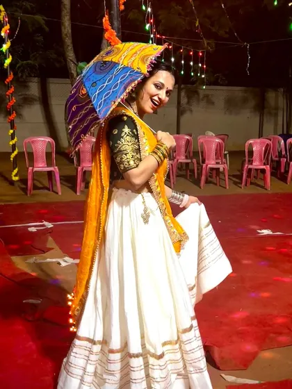 Having fun with a decorative umbrella, a popular prop in Garba and Rajasthani folk dances. We can incorporate props to make your performance even more unique.