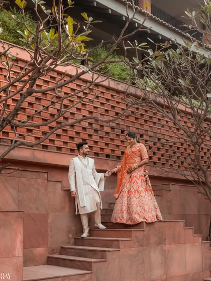 A candid moment captured as the couple descends a grand staircase. The natural interaction and the architectural elements combine to create a photo that feels both grand and personal.