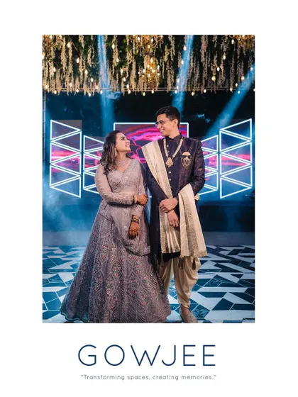 A beautiful portrait of the couple on their Sangeet stage, framed by dramatic lighting.
