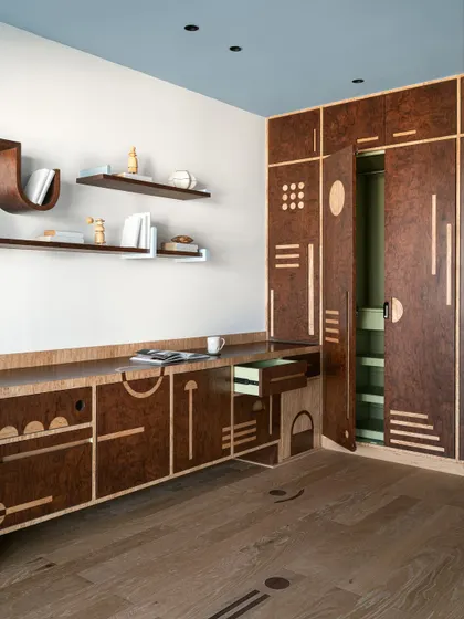 This multipurpose storage unit is a work of art in itself, featuring burl veneer and a playful composition of geometric motifs inlaid into the wood.